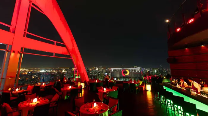 Red Sky Bar glowing in crimson above Bangkok’s city lights—a standout among the classy rooftop bars Bangkok serves up for mature solo travellers. Featured on The Road to Timbuktu, it’s the kind of place where you can sip a fine wine, soak in the skyline, and pretend you’re in a Bond film… without needing a Bond.