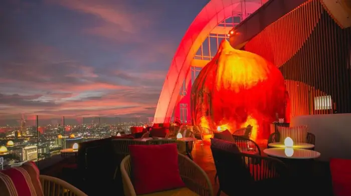 Red Sky Rooftop Bar glowing at sunset, with dramatic design and unbeatable rooftop views in Bangkok. Featured on The Road to Timbuktu, this stylish spot is perfect for solo travellers over 50 who like their skyline with a side of bold lighting and zero judgement.