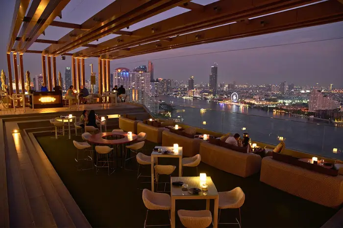 SEEN Bar’s candlelit terrace overlooking the Chao Phraya River—one of the most stylish rooftop bars in Sukhumvit for mature solo travellers. Featured on The Road to Timbuktu, this riverside retreat offers plush seating, panoramic views, and a cocktail list as smooth as the jazz playing in the background.