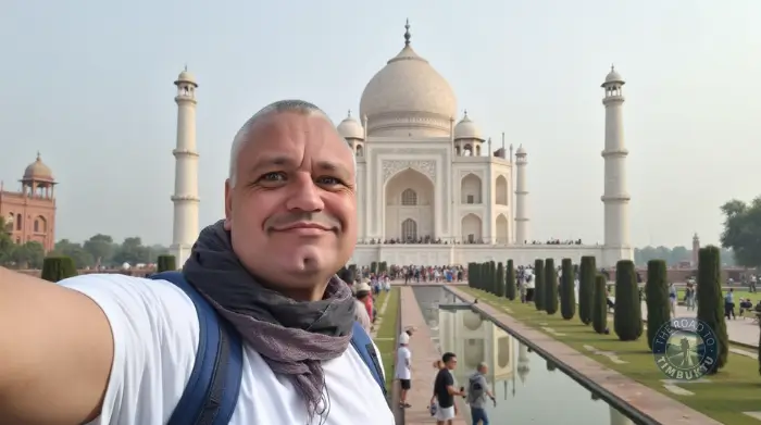 olo male traveller over 50 smiling in front of the Taj Mahal on a last-minute cultural adventure—living proof that love isn't a requirement for a great trip, but a solid selfie stick might be.